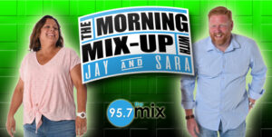 Two smiling radio hosts beside Morning Mix-Up logo